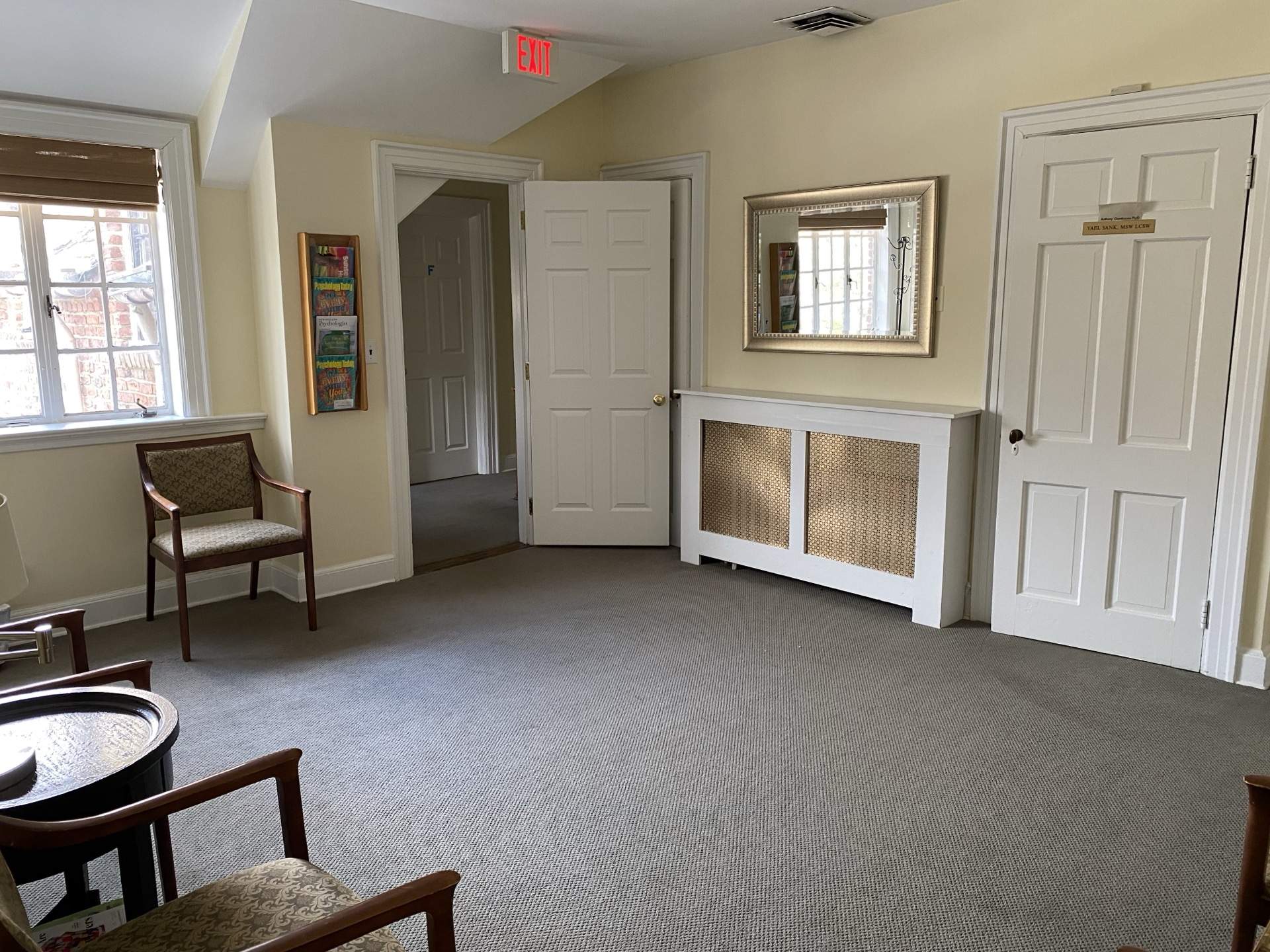 Common area with mirror, radiator cover, and chairs at The Phillips Mansion