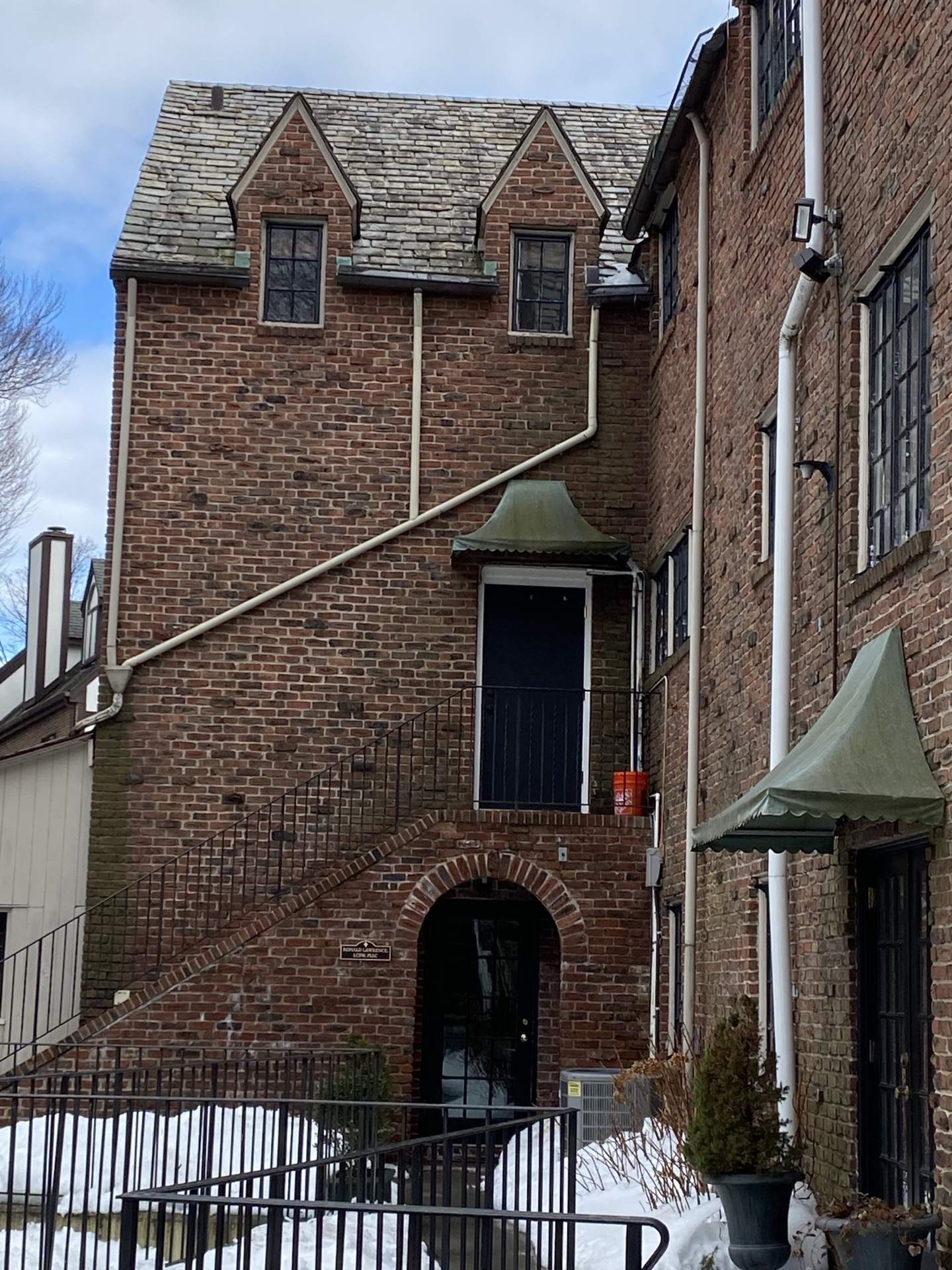 The arched brick entrance and Tudor facade of The Phillips Mansion