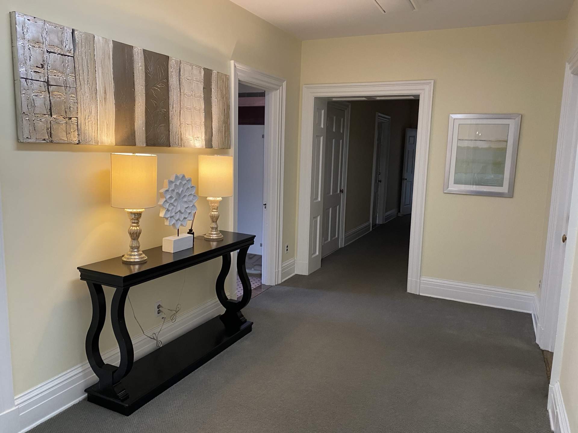 Elegant hallway with console table and artwork at The Phillips Mansion
