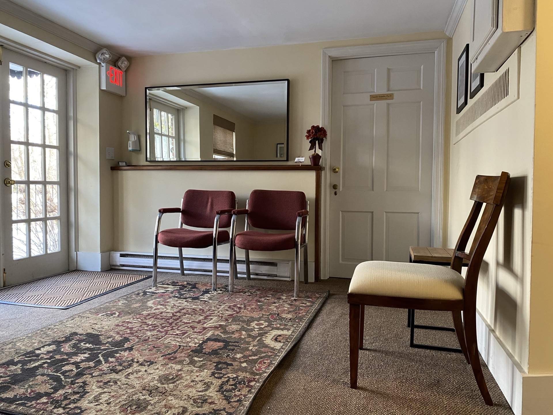 Interior office room with period chairs, table, and oriental rug at The Phillips Mansion