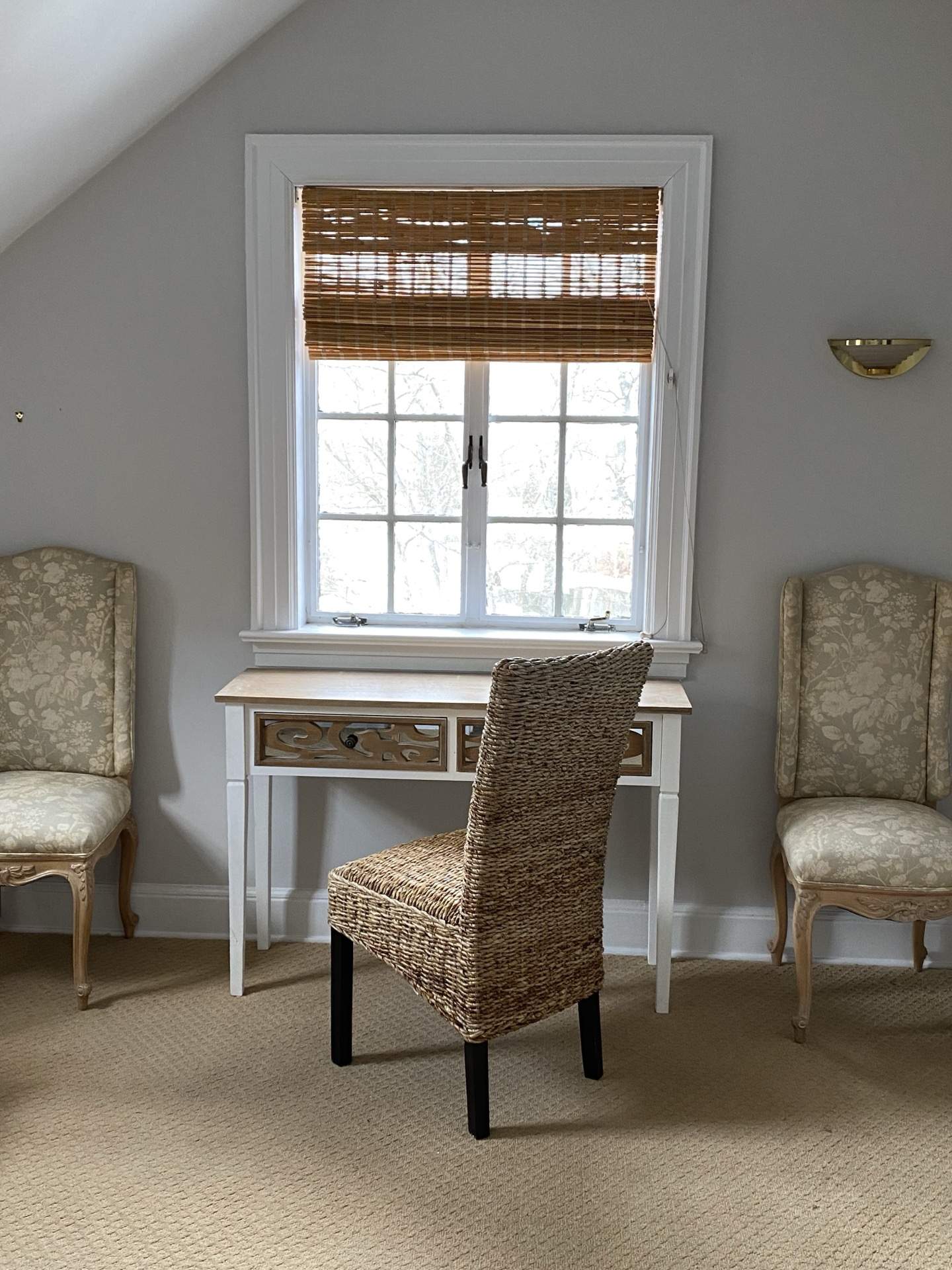 Room with window, wicker furniture, and upholstered chairs at The Phillips Mansion